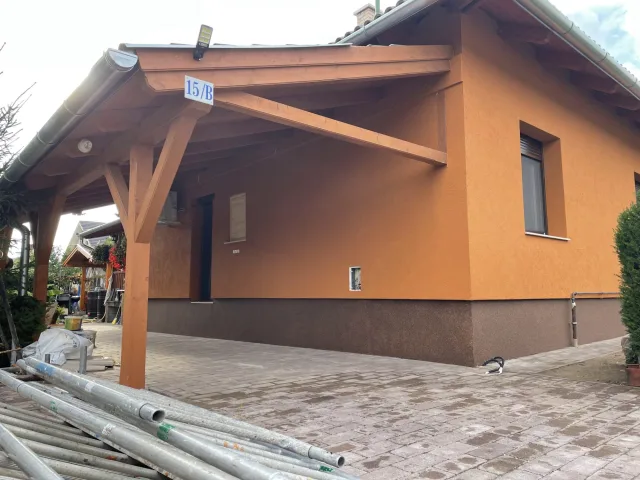 Kocsibeálló készítése egy vakolt családi ház mellett